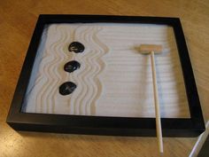 a wooden table with two black buttons and a white stick in a box on it