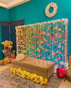 a room decorated with flowers and decorations on the wall, including a couch in front of a backdrop