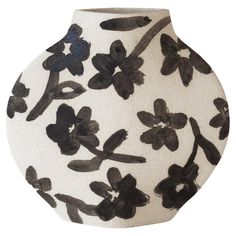 a black and white vase with flowers painted on it