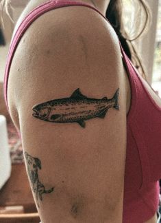 a woman with a fish tattoo on her arm