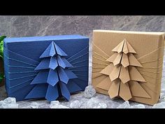 two origami christmas trees are sitting next to each other