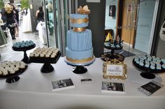 a table topped with lots of cakes and cupcakes