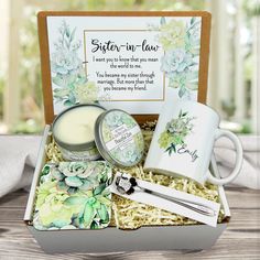 a gift box with candles, mugs and other items in it on a table