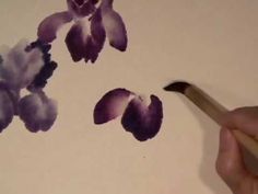 someone is drawing flowers on the wall with a paintbrush