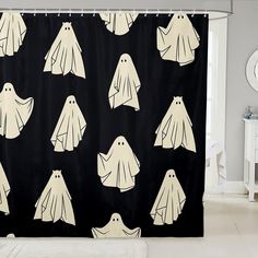 a black shower curtain with white ghost faces on it