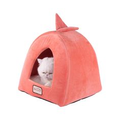 a white cat is laying in a pink kitty bed