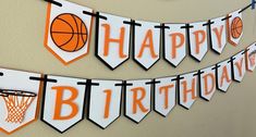 an orange and white birthday banner with basketballs on it, hanging from the wall