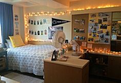 a dorm room with lights strung from the ceiling and pictures on the wall above the bed