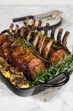 a roasting pan filled with meat and vegetables on top of a marble countertop