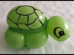 a green turtle toy sitting on top of a white sheet