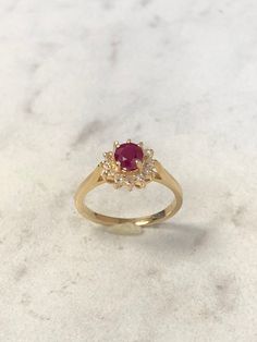 14kt Yellow Gold Lady's Diamond and Ruby Classic Halo Ring consisting of a 5mm round genuine Ruby with deep red color and tone 1/2ct approx. total weight prong set surrounded by accent diamonds .12ct total weight all prong set in solid heavy mounting in finger size 5 3/4. This item would Retail for $1,985.00 14k Gold Red Cluster Ring With Brilliant Cut, Gold Ruby Cluster Ring With Halo Design, Classic Red Cluster Ring, Classic 14k Gold Ruby Ring With Halo Design, Red Brilliant Cut Birthstone Ring In 14k Gold, Red 14k Stamped Cluster Ring, Red Cluster Ring Stamped 14k, Classic Round Ruby Ring With Halo Design, Red Cluster Ring With Prong Setting, Round Cut