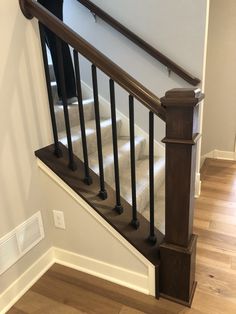 an empty staircase with white carpet and wooden handrails in a home's entryway