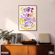 a poster hanging on the wall above a wooden cabinet with a record player next to it