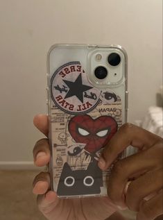 someone holding up their phone case with an image of a cat and spiderman on it