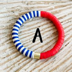 a red, white and blue bracelet with the letter a on it's side