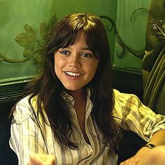 a woman sitting at a table with a plate of food in front of her smiling