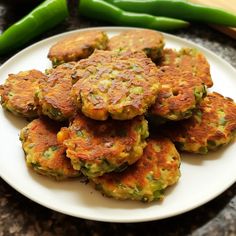 a white plate topped with crab cakes next to green beans and jalapenos