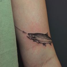 a fish with a fishing hook tattoo on the arm