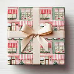 a present wrapped in wrapping paper with a bow on the front and side of it