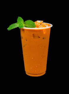 an orange drink with ice and mint garnish