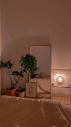 a bedroom with a bed, mirror and plant