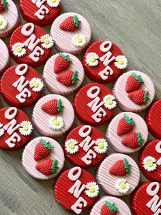 red and white cupcakes with strawberries on them are arranged in the shape of hearts