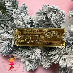 a close up of a christmas ornament on top of a snow covered tree