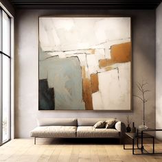 an abstract painting hangs on the wall next to a couch in a room with wooden floors