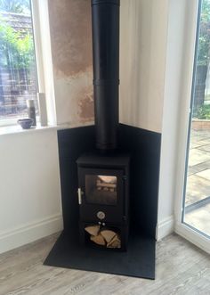 a wood burning stove sitting inside of a living room next to a sliding glass door