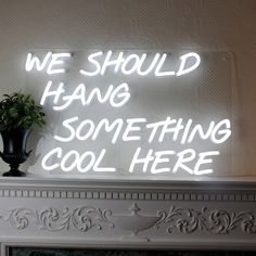 a neon sign that says we should hang something cool here on the fireplace mantel