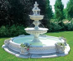 a water fountain in the middle of a grassy area