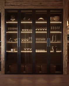 an empty glass cabinet in a kitchen with wooden walls and floor to ceiling shelves filled with dishes