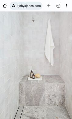 a white towel hanging on the side of a wall next to a soap dispenser