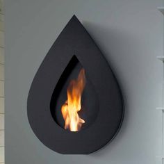 a fire is lit inside of a tear shaped wall mounted fireplace in a modern home