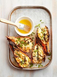 grilled lobsters on a tray with dipping sauce