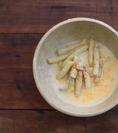 a white bowl filled with food on top of a wooden table