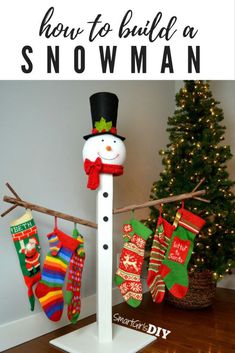 a snowman made out of socks and stockings hanging on a clothes line next to a christmas tree