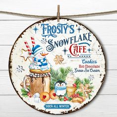 frosty's snowflake cafe sign hanging on a white wooden wall with christmas decorations