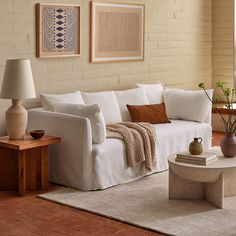 a living room with white couches and two lamps on either side of the couch