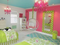 a bedroom with pink walls and green bedding, chandelier hanging from the ceiling