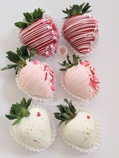 four chocolate covered strawberries sitting on top of each other with pink flowers and leaves