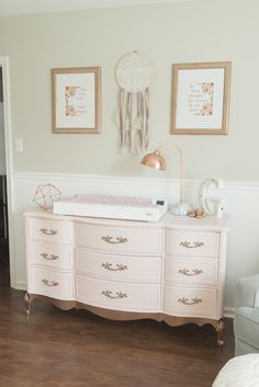 a baby's room with pink dressers and pictures on the wall above them