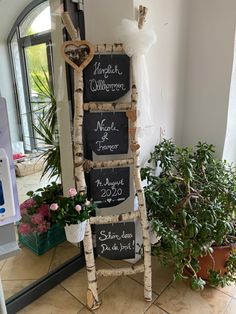 a ladder made out of wine corks with wedding signs attached to the side and flowers