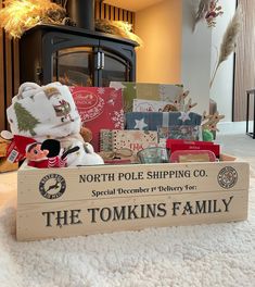 a teddy bear sitting in a wooden crate filled with christmas cards and other holiday items