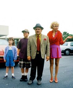 a man and two children are standing in the parking lot