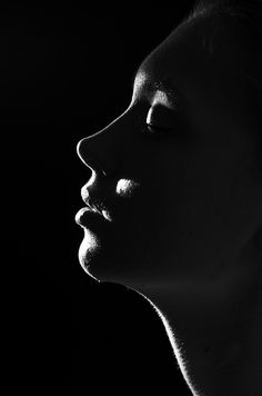 a black and white photo of a woman's face with her eyes closed to the side