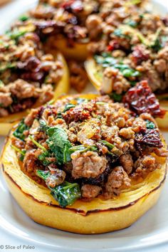 stuffed squash topped with meat and spinach on a white platter, ready to be eaten