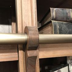 books are stacked on top of each other in a book shelf with a metal rod