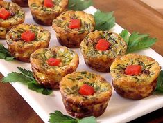 there are many small muffins on the white plate with green garnish