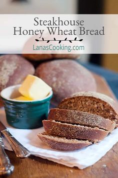 bread and butter on a wooden table with text overlay that reads steakhouse honey wheat bread